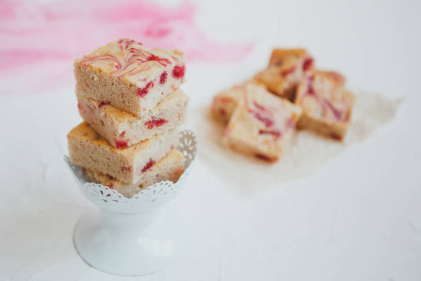 Homemade blondies, made of white chocolate with fresh raspberries, on a light background. Homemade blondies, made of white chocolate with fresh raspberries, on a light background. blondy stock pictures, royalty-free photos & images
