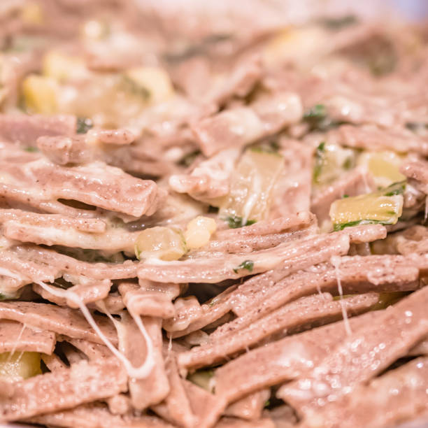 very close up of the succulent and typical italian dish pizzoccheri in a white plate on a table. typical dish from valtellina, lombardy, italy. - pizzoccheri homemade tagliatelle italy imagens e fotografias de stock