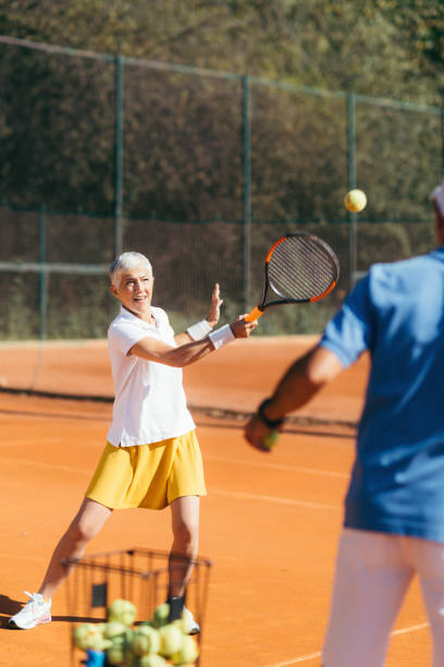 istock Older Woman Practicing Tennis with Instructor 1226780233