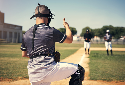 Image of a baseball catcher ready to catch baseball. He is wearing unbranded generic baseball uniform. The game takes place on outdoor baseball stadium full of spectators. The stadium is made in 3D.