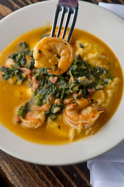 shrimp and cheese grits served with saffron sautéed southern vegetables. classic southern breakfast or brunch favorite. - grits prepared shrimp restaurant food imagens e fotografias de stock