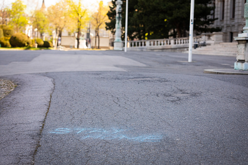 stay home message written with blue chalk on a pathway in Vienna