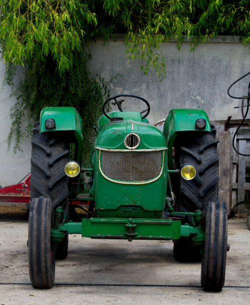 Old parked green tractor in France