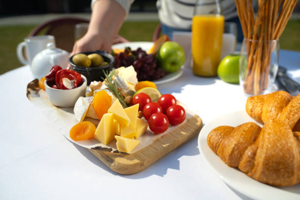 Close up of female hands setting table with delicious healthy food stock photo