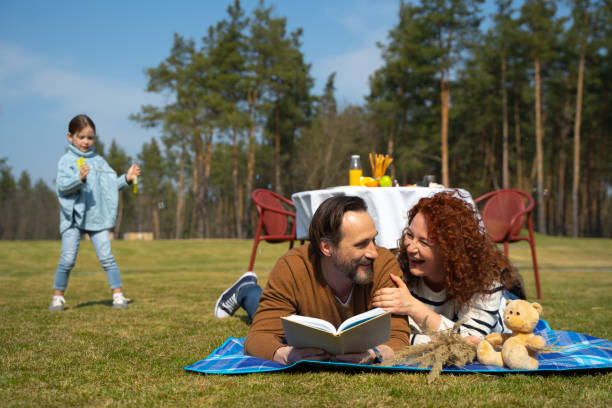 istock Cheerful married couple lying on blanket on green grass 1226793472