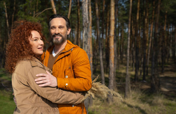 istock Happy husband and wife hugging in pine forest 1226793488
