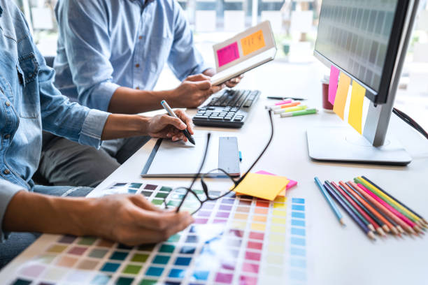 istock Young colleagues designers working together on a creative project and color samples for selection, Color swatch samples, Brainstorming Planning Partnership, creative graphic design working desktop 1226793590