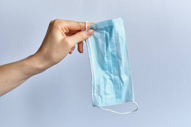 istock A hand holds a medical protective mask on a white background. 1226797226