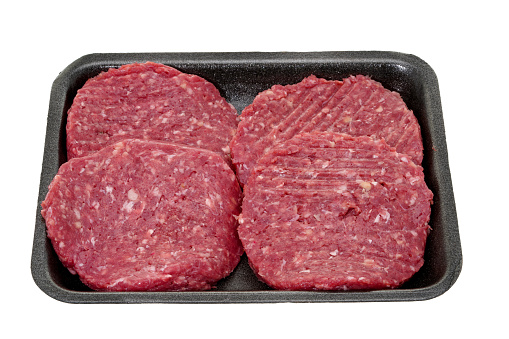 Four raw meat burger patties in retail packaging - white background
