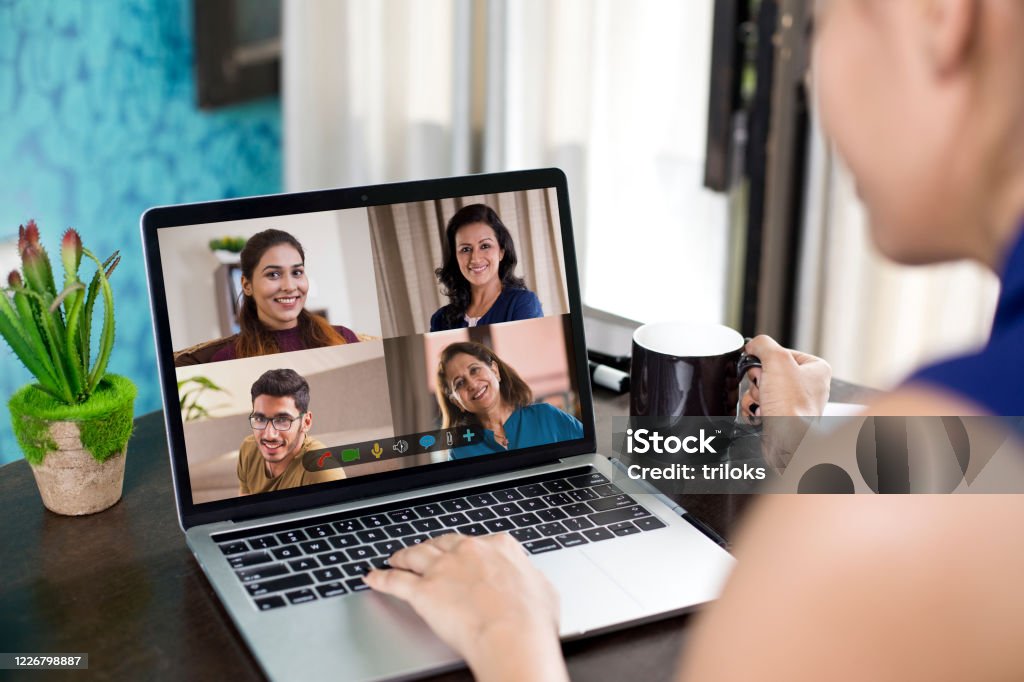 Women attending business video call from home Women attending business video call meeting using laptop at home India Stock Photo
