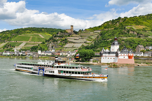 Boppard, Germany, June 8, 2009:  A view across the River Rhine and  the village of Kaub in Germany.  A Rhine passenger ship passes the Burg Pfalzgrafenstein which is on an island in the middle of the Rhine river  which flows through an area known as the Rhine valley  and is popular with tourists from all over the world.