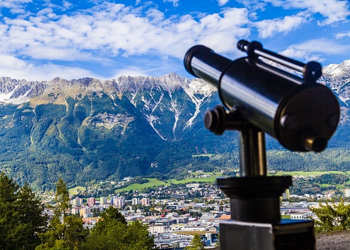Whole city and alps mountain landscape with telescope.
