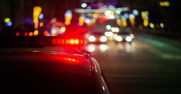 police car lights in night city with selective focus and bokeh - policia imagens e fotografias de stock