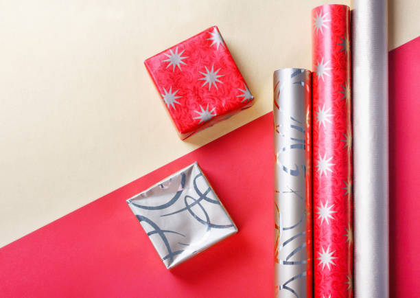 istock Golden gift boxes and red wrapping paper on bright background 1226804455