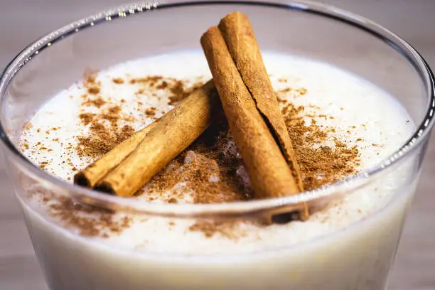 Creamy rice pudding sprinkled with cinnamon, typical Brazilian dessert.
