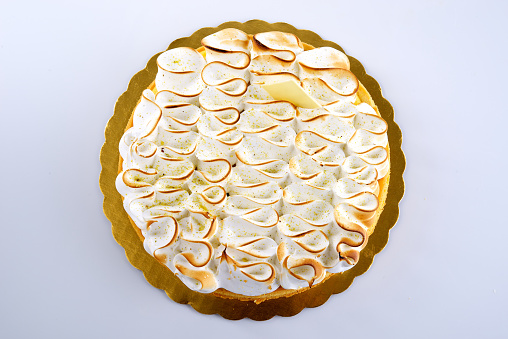 Lemon tart topped with citrus slices and zest on white table background, top view. Copy space. Traditional french cuisine