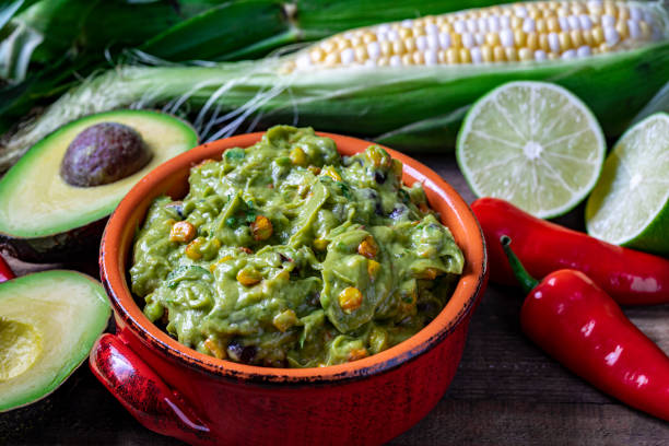 istock Fresh guacamole in red clay dish with corn tortilla chips and raw ingredients. 1226807069