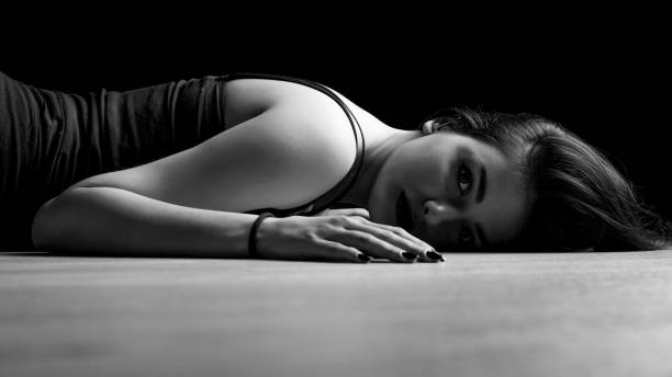 portrait of young woman lying down on a floor stock photo