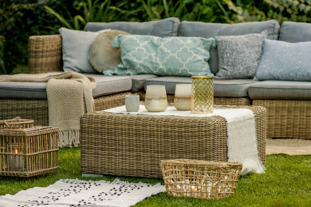 istock Lanterns, candles and vases on wicker coffee table in front of garden sofa 1226810758