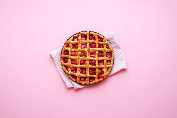 Rhubarb-strawberry pie freshly baked. Lattice crust pie top view Homemade rhubarb and strawberries pie on a pink background, above view. Flatlay with a freshly baked lattice crust pie rhubarb stock pictures, royalty-free photos & images