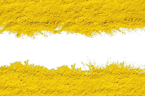 Abstract background of yellow dry powder paint. Copy space in a white stripe.