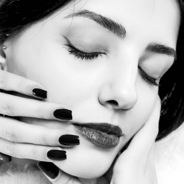 istock Black and white young woman touching her face isolated on white background. 1226813256