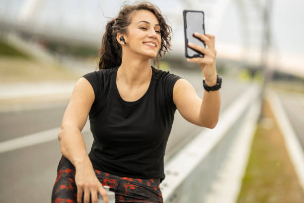 istock Sporty woman using mobile phone and drinking water 1226813688