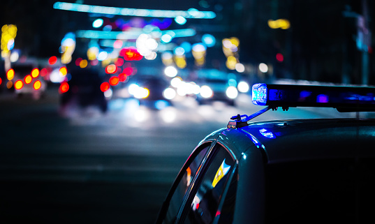 night police car lights in city - atmospheric close-up with selective focus and bokeh background blur