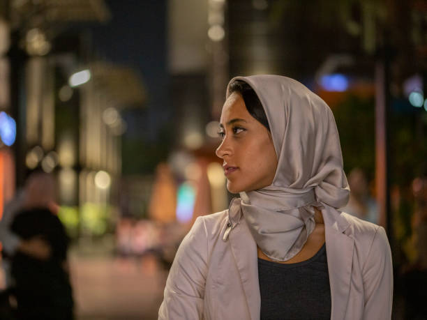 donna mediorientale che indossa l'hijab nella città illuminata - milfeh foto e immagini stock