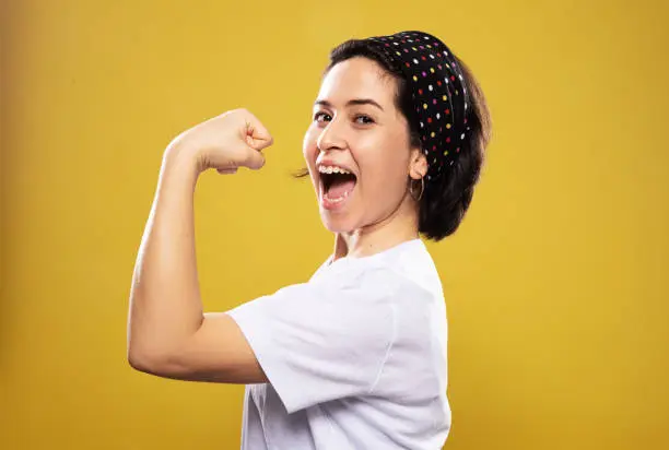 Photo of Strong woman portrait front of yellow background