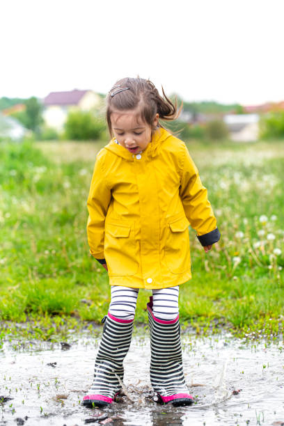 istock A child in rubber boots jumps in a puddle. 1226819671