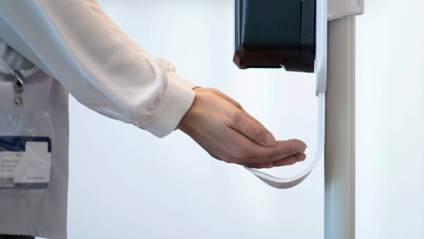 istock Medical Professional using a touchless sanitizer dispenser 1226819940