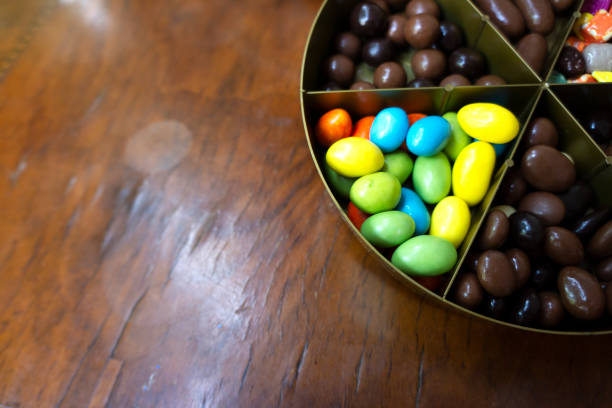 Multicolored chocolate candies on wooden table.