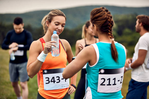 istock Young athletic women talking while resting from a marathon  in nature. 1226822752