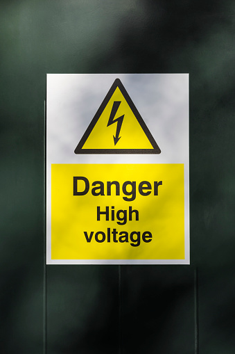 Rectangular white, black and yellow warning sign to inform people of high voltages.