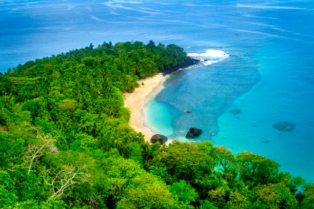 The most famous beach in Principe Island, the tiny island of São Tomé and Principe, on the west coast of Africa. This is perfect for swimming, with white sand curving in a banana shape around turquoise waters