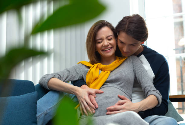 istock Pregnant woman laughing while feeling her baby pushing inside 1226827570