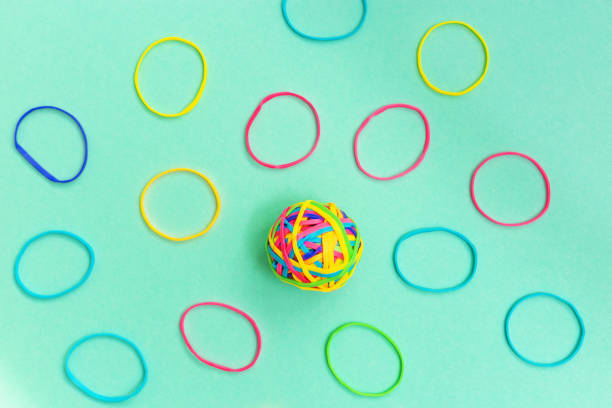 palla o nodo di sottili gomme elastiche multicolori su sfondo semplice. groviglio di pensieri. - flexibility rubber rubber band tangled foto e immagini stock