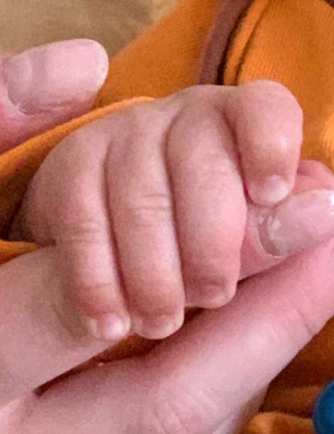 istock small baby hand grabs mother's fingers, close-up 1226829434