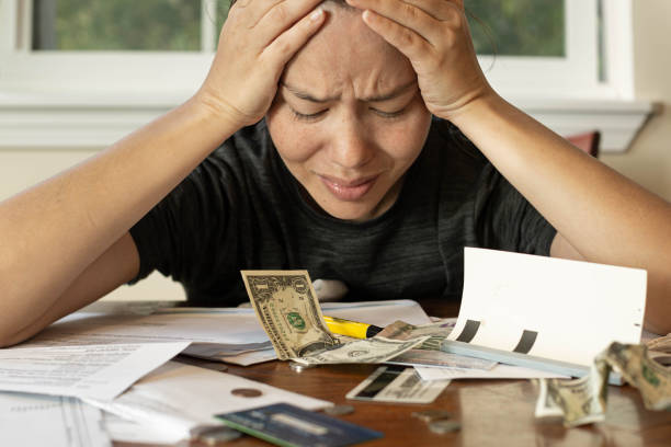 femme regardant ses factures financières stressées ; pas d’argent/faillite - unemployment fear depression women photos et images de collection