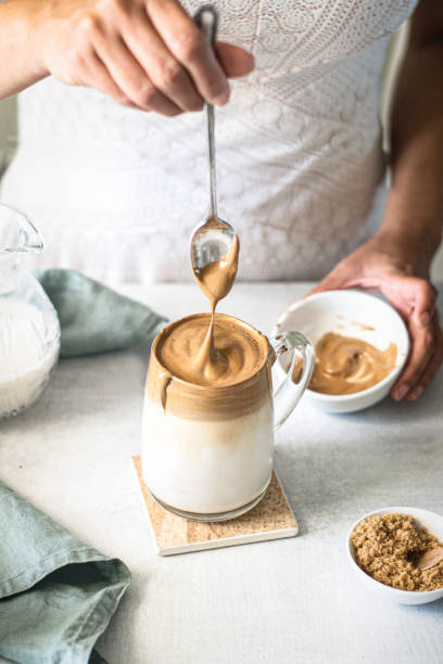 istock Dalgona Coffee, A woman in pouring fluffy whipped coffee on milk 1226832406