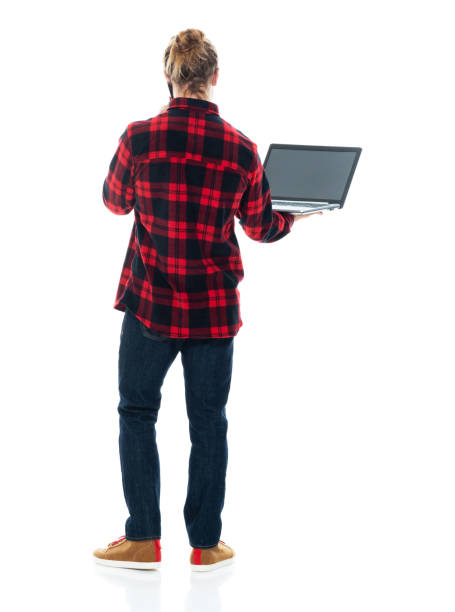 istock Caucasian male standing in front of white background wearing shirt and using computer 1226833444