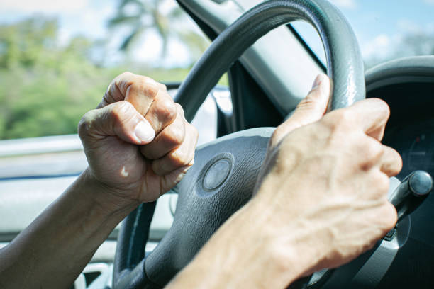 Angry driver honking and beeping the horn. Road rage. A man behind the steering wheel angry at other drivers banging on his horn in anger. aggression stock pictures, royalty-free photos & images