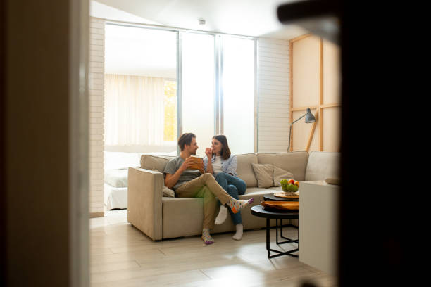 istock Young couple sitting on sofa in living room 1226834343