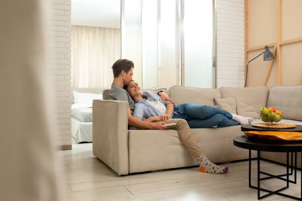 istock Young smiling couple watching TV in room 1226834368