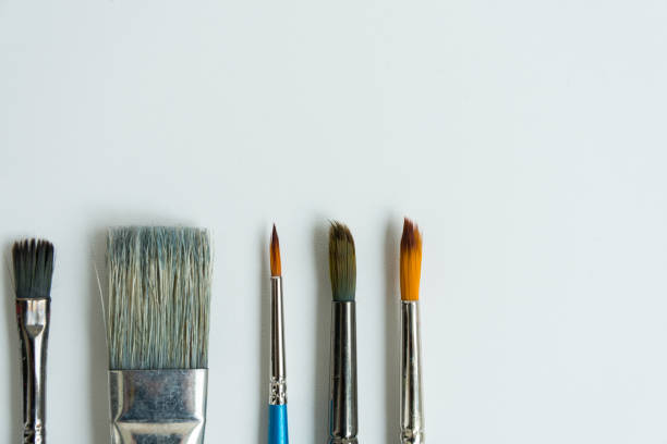 istock At the bottom, on a clean white sheet, there are brushes for drawing with paints. Brushes of different shapes and sizes. Postcard, background, texture. Space for text. The view from the top. 1226834473