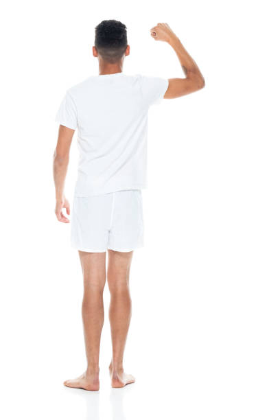 афро-американской этнической принадлежности молодой му�жчина, стоящий перед белым фоном носить нижнее белье - underwear men t shirt white стоковые фото и изображения