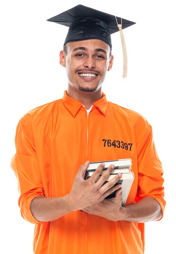 One person of aged 20-29 years old generation z male university student standing in front of white background wearing jumpsuit who is studying and holding textbook
