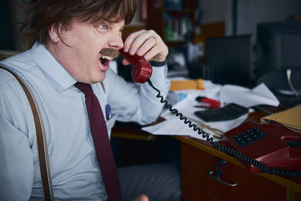 istock Furious broker shouting to the phone in his office 1226843057