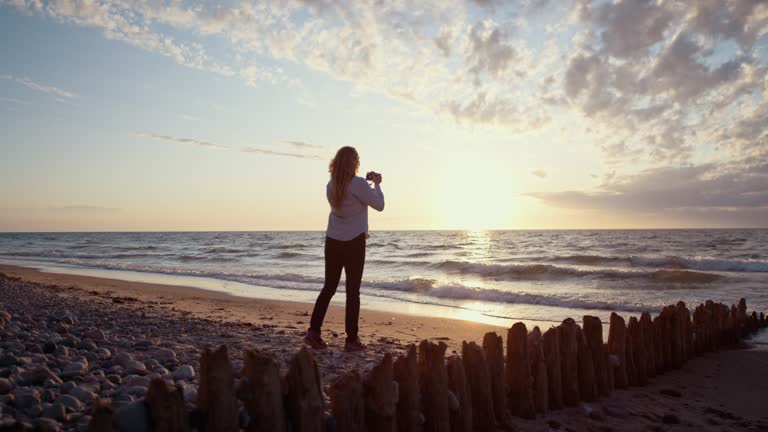 Photographer On Beach At Sunset